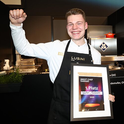 Koch posiert als ersten Platz des next Chef Award vor de Kamera.