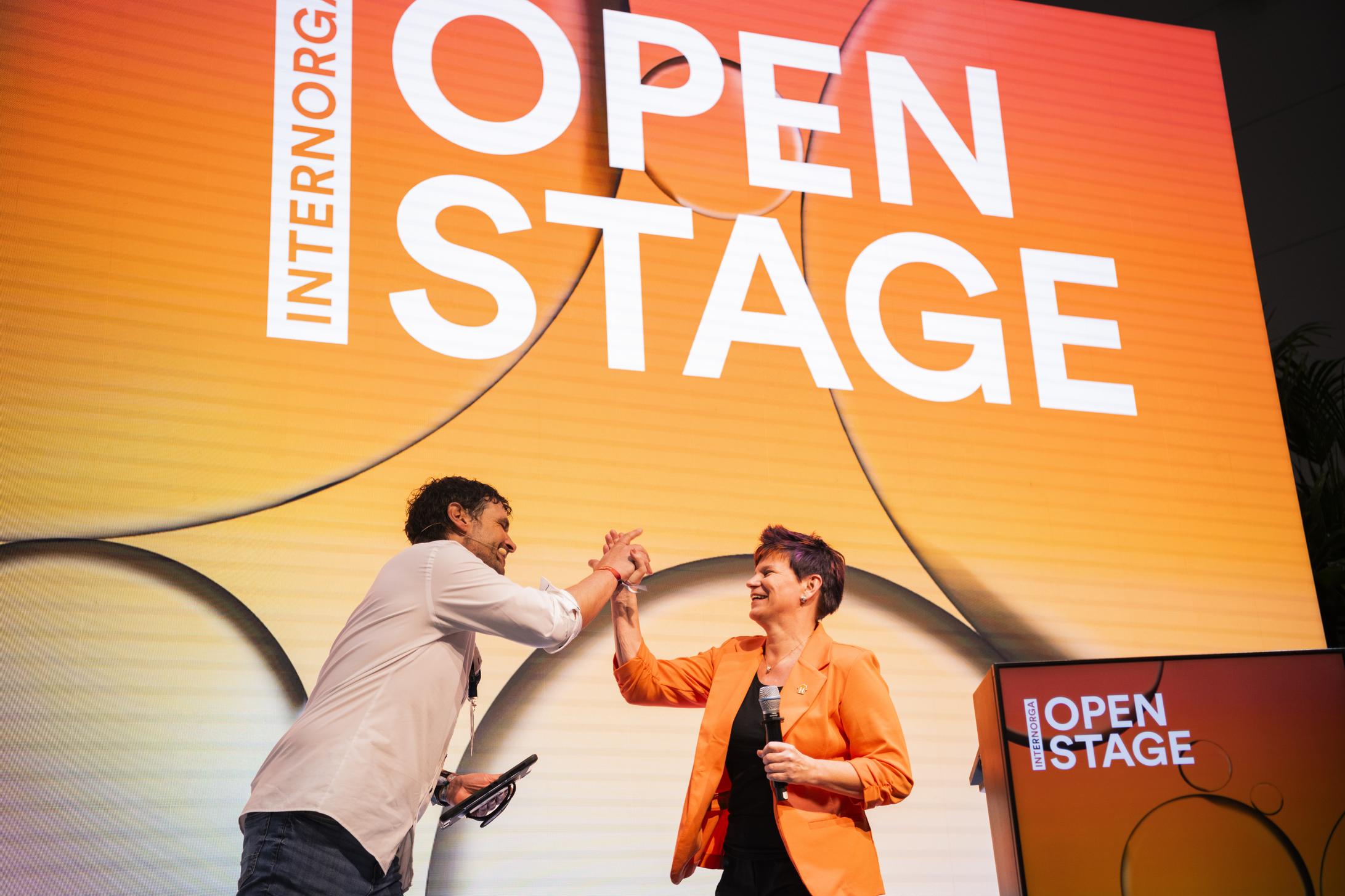 Open Stage close-up with two speakers giving each other a high five